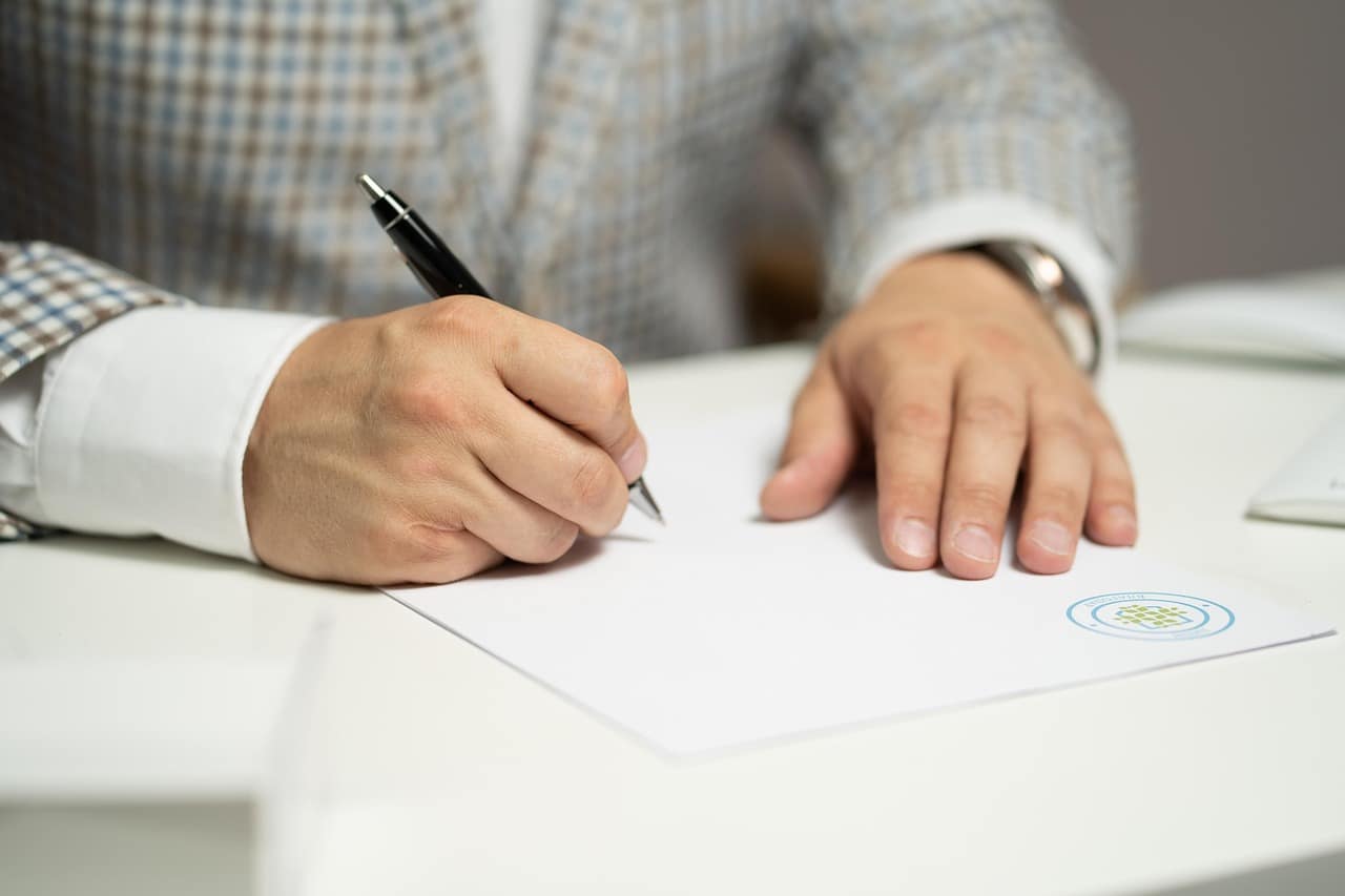 Persona firmando un contrato, referencia a los cupos cerrados meses antes de la temporada