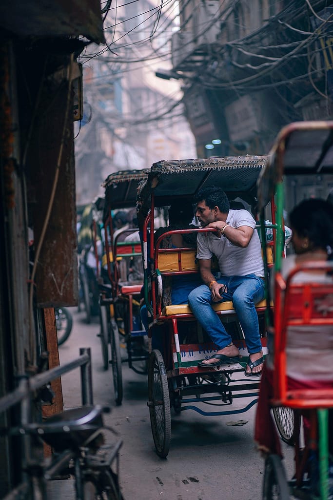 Rickshaws en fila en una calle concurrida de India — metáfora de la dependencia de canales de distribución hotelera