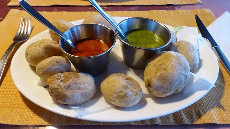 Plato de papas arrugadas con mojo rojo y mojo verde, representando dos estilos de decisión en la gestión hotelera.