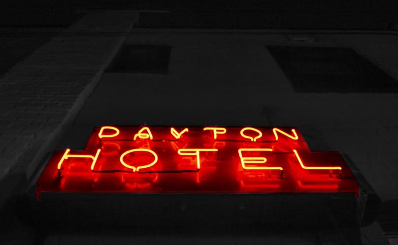 Letrero de neón de hotel encendido de noche: por qué mi hotel depende tanto de Booking