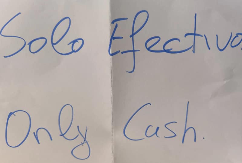 Cartel escrito a mano con la frase “Solo efectivo. Only cash.”, típico de establecimientos rurales o refugios donde no se aceptan pagos digitales.