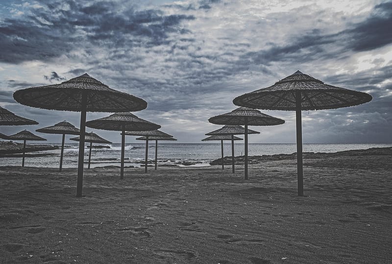 Por qué mi hotel no vende en temporada baja: sombrillas vacías en una playa fuera de temporada